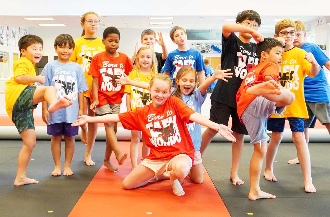 Kids practicing high-energy martial arts kicking drills during summer camp at ABBA Martial Arts in Peachtree City.