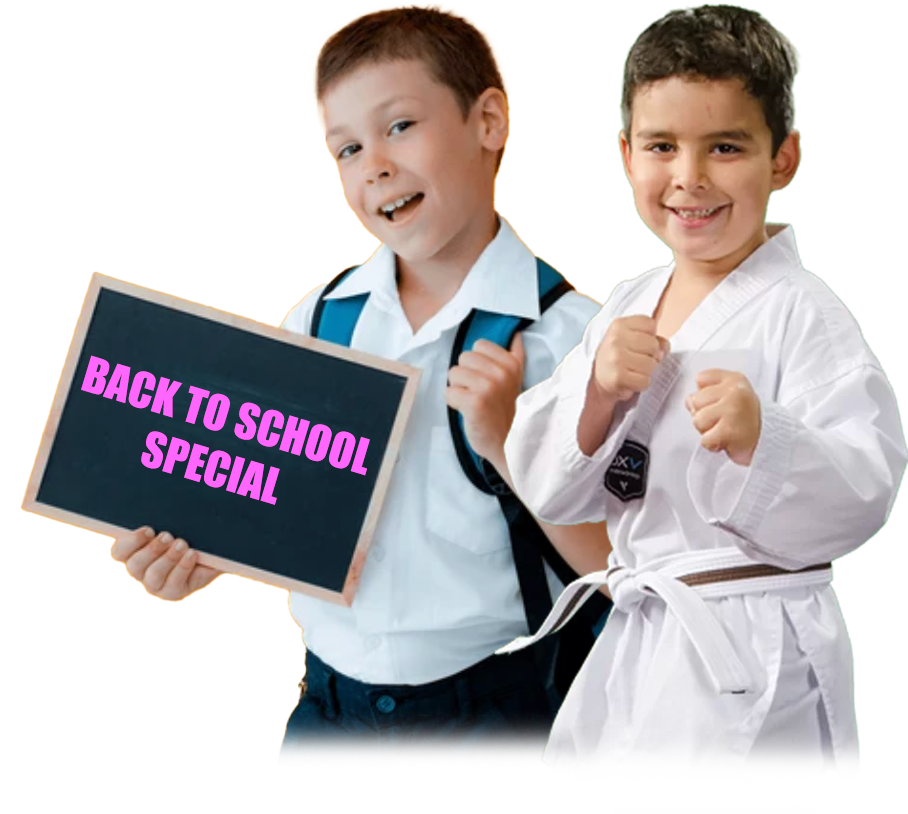 Two smiling kids, one in a school uniform and one in a Taekwondo uniform, holding a Back to School Special sign at a martial arts school in Peachtree City