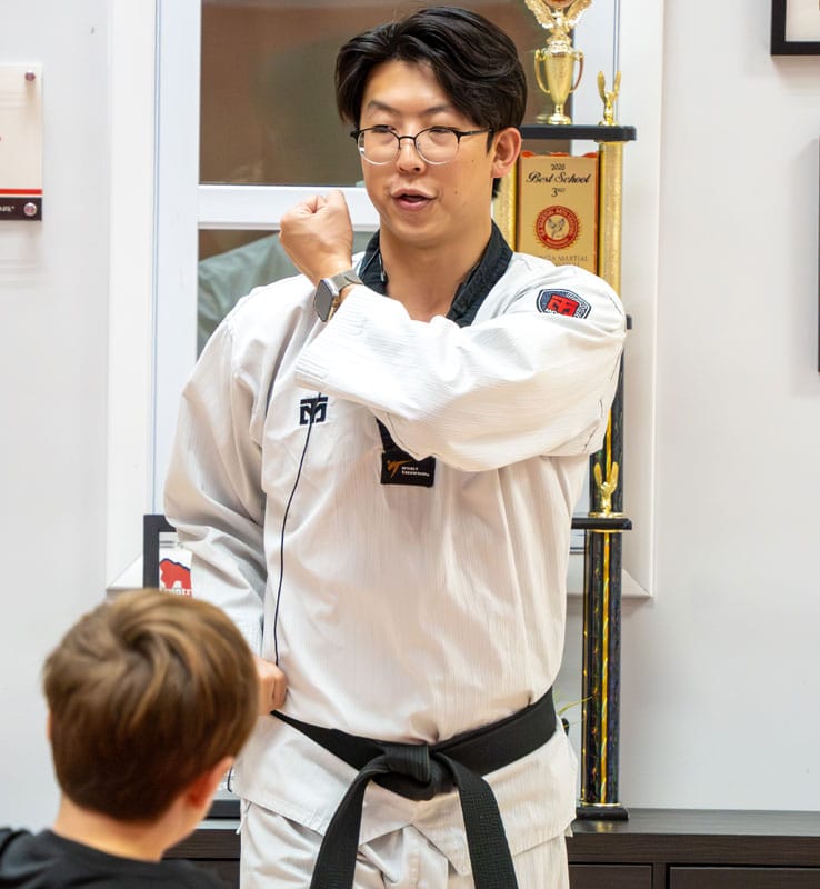 master-jeong-is-teaching-taekwondo-class-in-peachtree-city Taekwondo instructor demonstrating a technique to a student at American Black Belt Academy in Peachtree City, Georgia