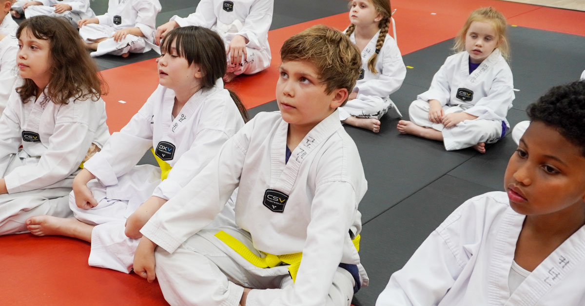 Taekwondo instructor teaching children the importance of focus and self-control.