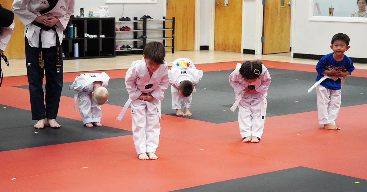 A shy child starting their first Taekwondo class, learning to say hello with confidence.