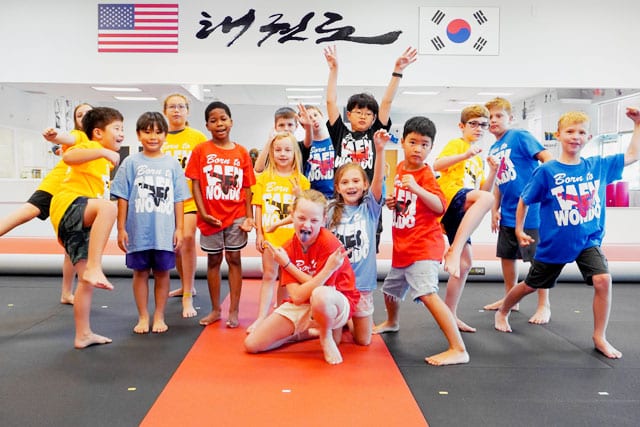 Kids having fun together during a high-energy martial arts summer camp activity.