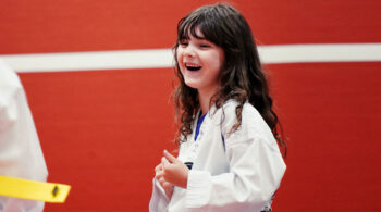 Happy young girl in a Taekwondo uniform smiling during summer martial arts training
