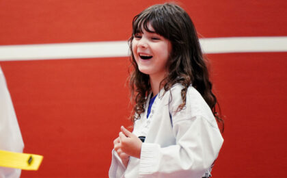 Happy young girl in a Taekwondo uniform smiling during summer martial arts training